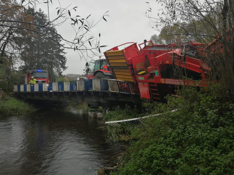 Ciągnik z maszyną rolniczą zawisł na moście! ZDJĘCIA 